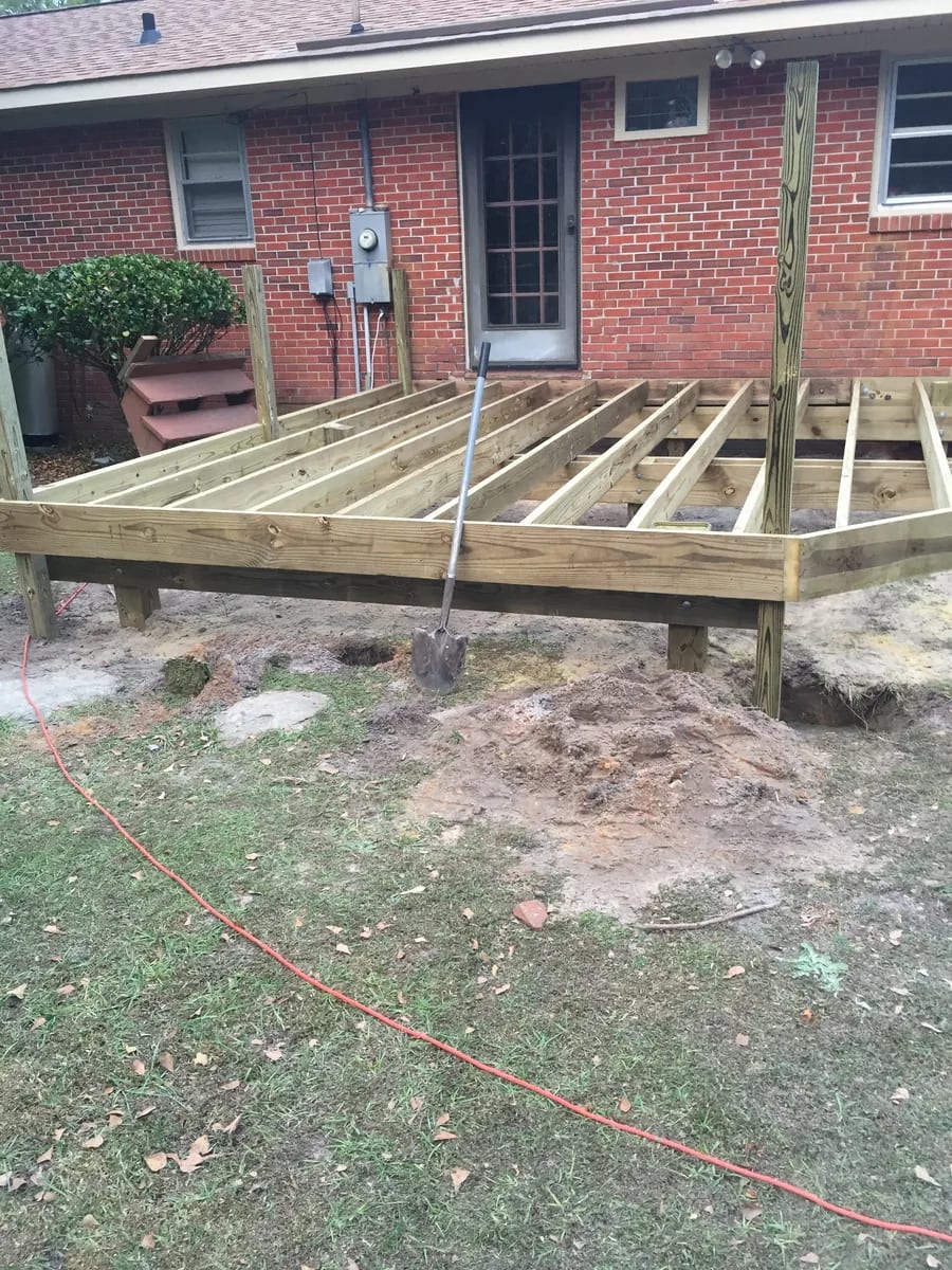 Wood deck frame with railing supports being assembled