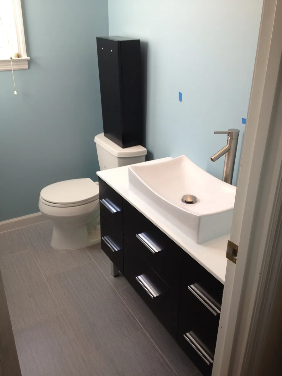 Bathroom with vanity, vessel sink, toilet, and finished floor visible