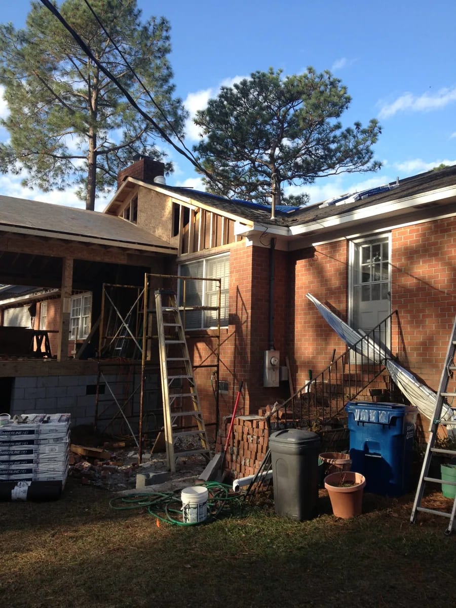 Exterior construction view beside a brick home