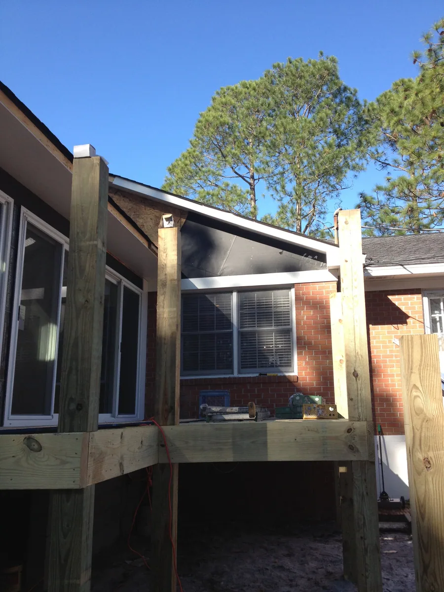 Exterior view of an enclosed addition beside a brick home