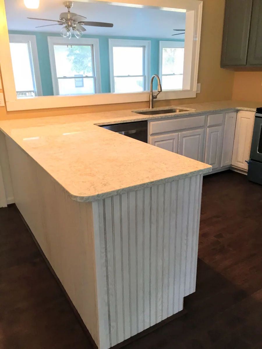 Kitchen with cabinets, countertops, sink, and flooring visible