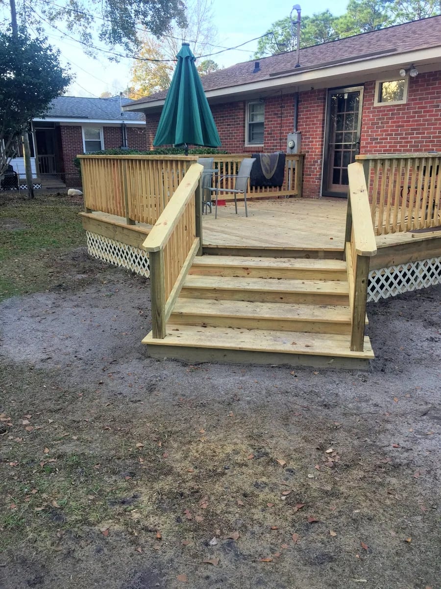 Wood deck with stairs, railings, deck boards, and lattice visible